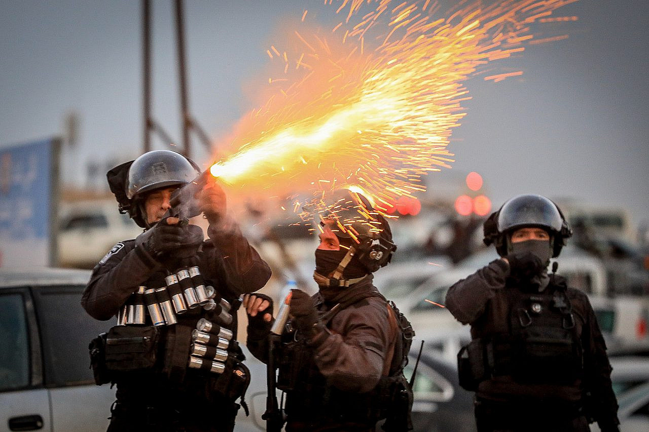 Israeli police officers fire tear gas at Bedouin citizens during a protest against tree planting by the Jewish National Fund, outside the Bedouin village of al-Atrash in the Negev, Israel, January 13, 2022. (Jamal Awad/Flash90)