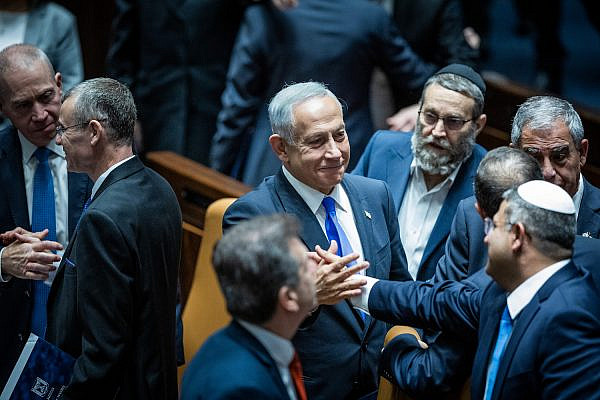 Prime Minister Benjamin Netanyahu shakes hands with Otzma Yehudit party head Itamar Ben Gvir during a Knesset session to vote on forming the government, December 29, 2022. (Yonatan Sindel/Flash90)