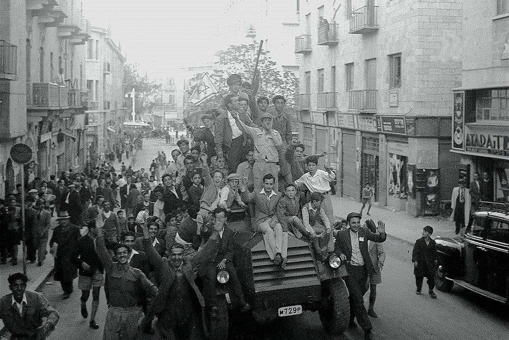 Jewish Jerusalemites celebrating the UN decision on the partition of Palestine, riding on top of an armored police car, Jerusalem, 1947, November 30, 1947. (Hans Pinn/GPO)