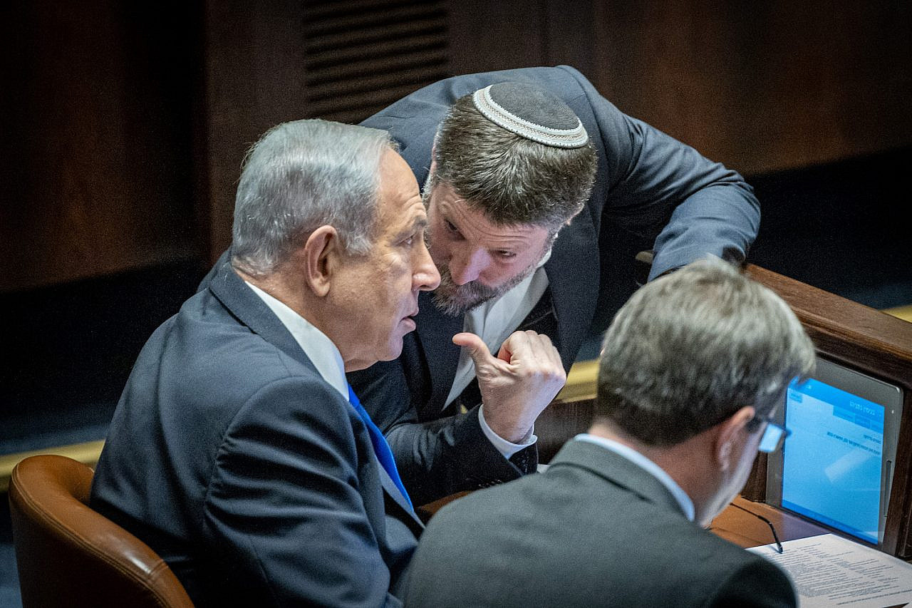 Prime Minister Benjamin Netanyahu speaks with Finance Minister Bezalel Smotrich in the Knesset, December 20, 2022. (Yonatan Sindel/Flash90)
