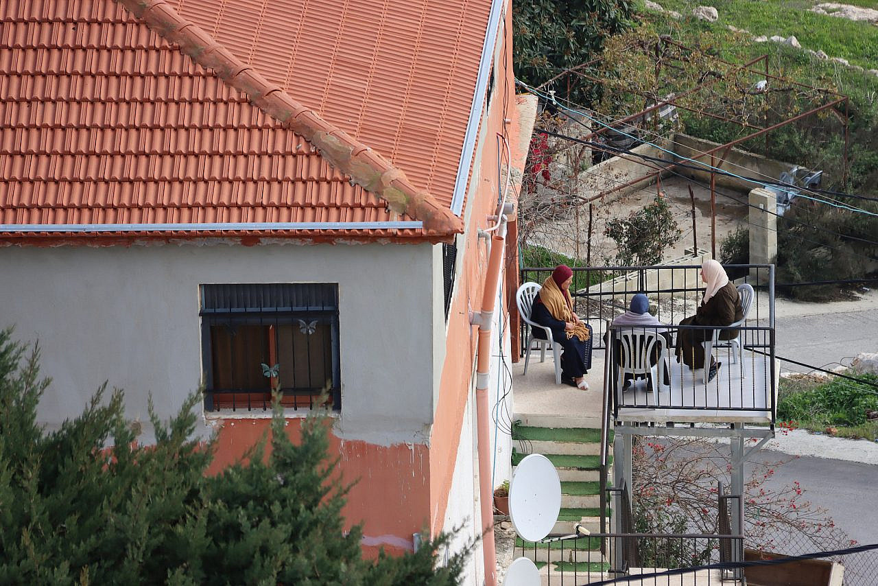 Residents of Farkha gather on a balcony in the village, January 10, 2023. (Ahmad Al-Bazz)
