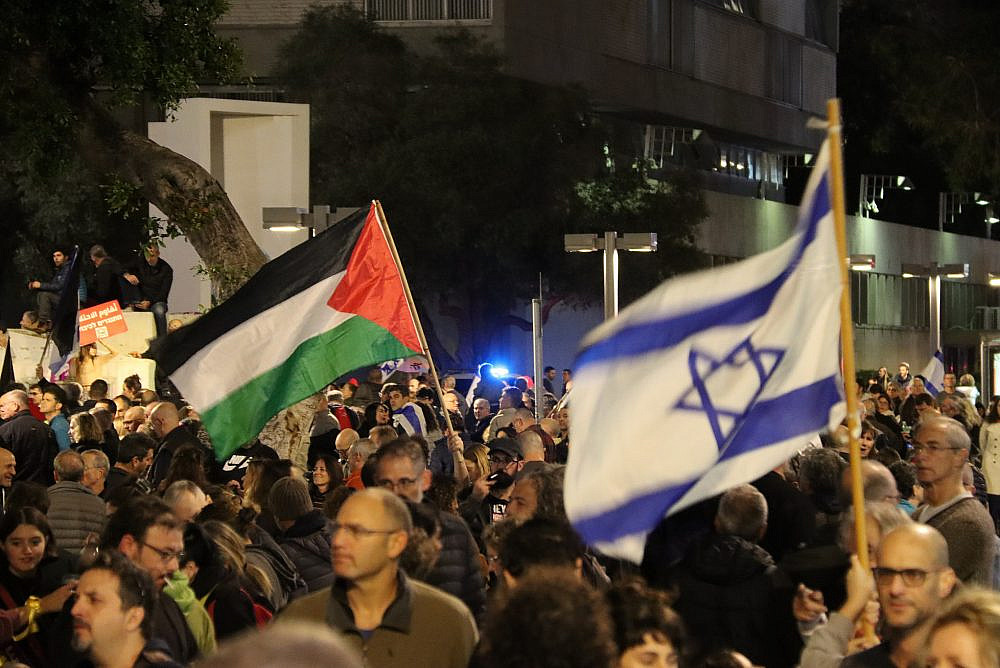 Israeli and Palestinian flags are seen at an anti-government demonstration in Tel Aviv, January 7, 2022. (Ahmad Al-Bazz)