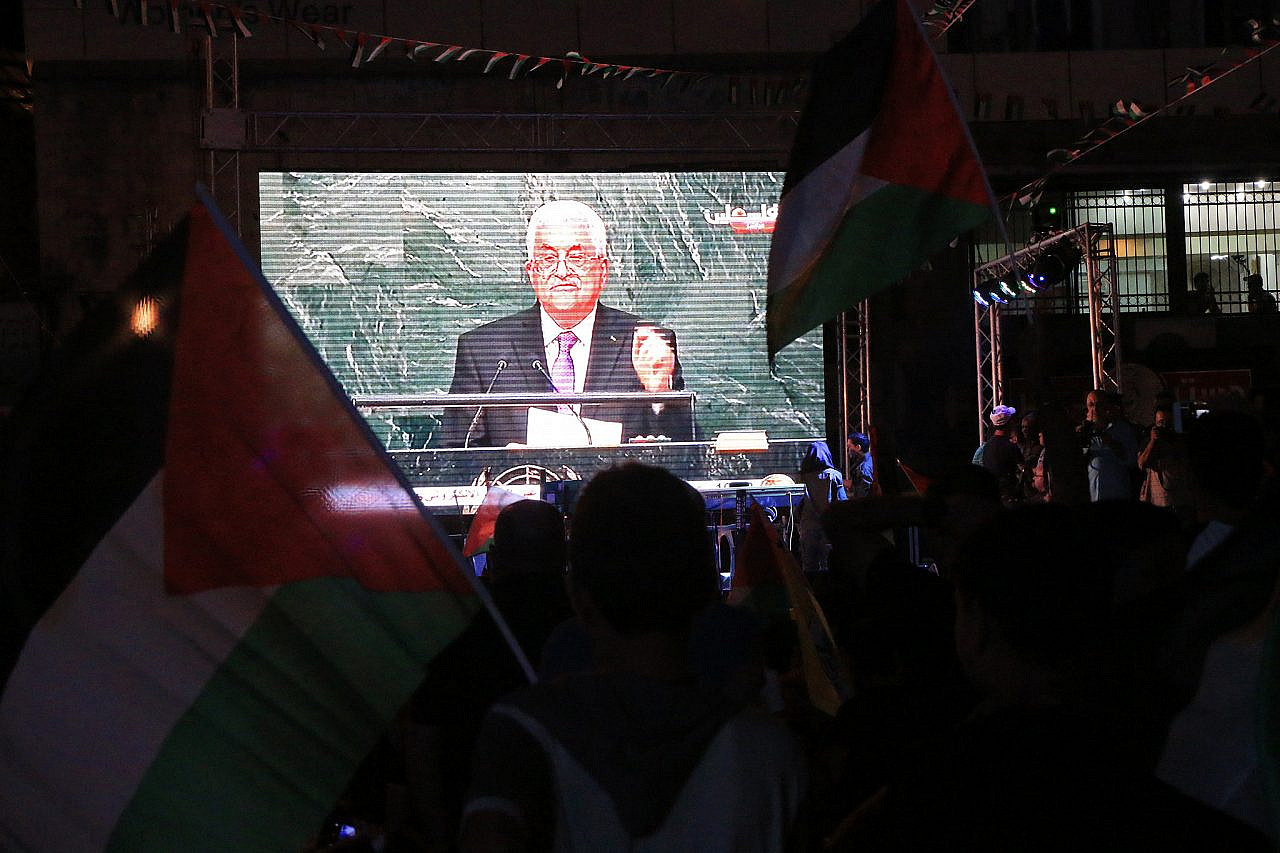 Palestinians wave their national flags as they watch a live-screening of President Mahmoud Abbas' speech followed by the raising of the Palestinian flag at the United Nations headquarters in New York, in the occupied West Bank city of Nablus, September 30, 2015. (Ahmad Al-Bazz/Activestills)