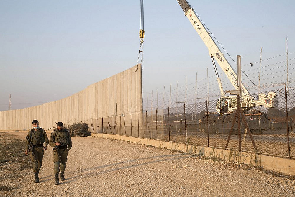 Israeli authorities installing a new section of the wall around Qalqilya, occupied West Bank, replacing the existing fence which has several holes created by Palestinians for crossing into Israel for work, January 10, 2021. In 2004, the International Court of Justice stated that the West Bank wall is "illegal and must be dismantled." (Keren Manor/Activestills)
