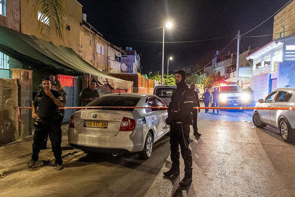 Police and medical personnel at the scene investigate the murder of a woman in her 30's that was shot dead, in Lod, July 26, 2022. (Yossi Aloni/Flash90)