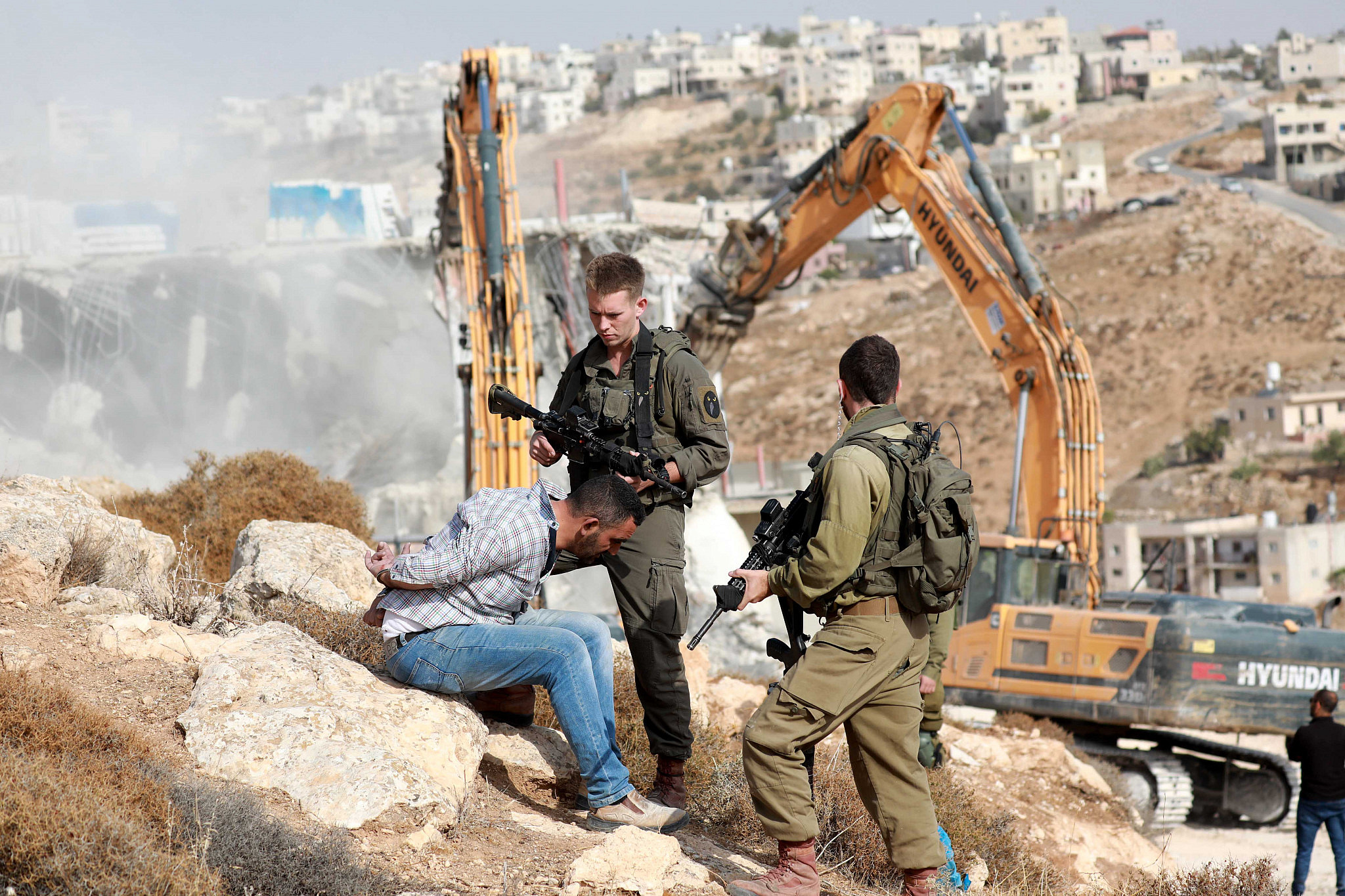 Palestinians clash with Israeli security forces as Israeli bulldozer demolishes a Palestinian house in the West Bank city of Hebron, October 25, 2022. (Wisam Hashlamoun/Flash90)