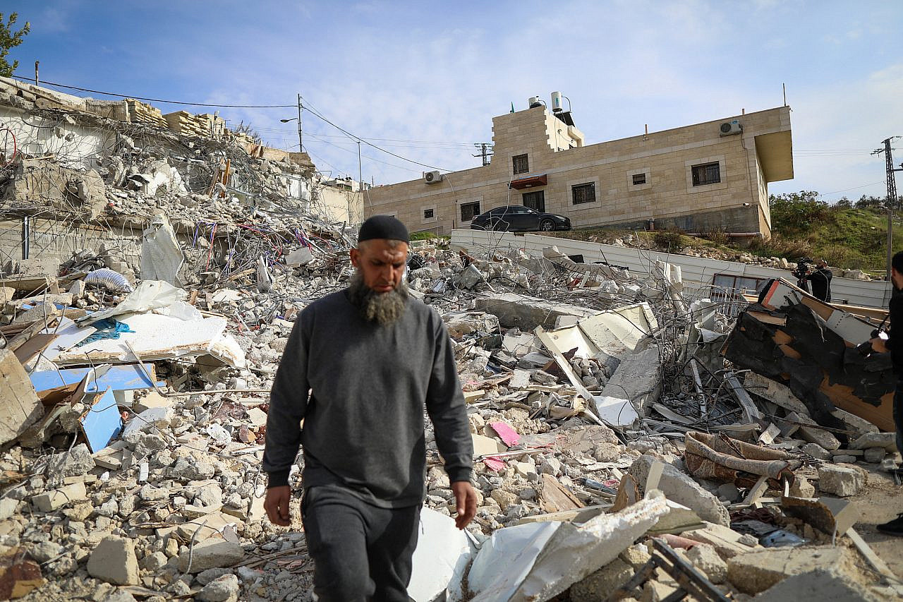 A Palestinian walks through the rubble of a building that was demolished by Israeli security forces in the Jerusalem neighborhood of Jabel Mukaber, January 29, 2023. (Jamal Awad/Flash90)