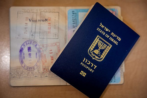 An illustration of a new Israeli passport and an old Israeli passport with different stamps in Jerusalem, January 18, 2023. (Nati Shohat/Flash90)