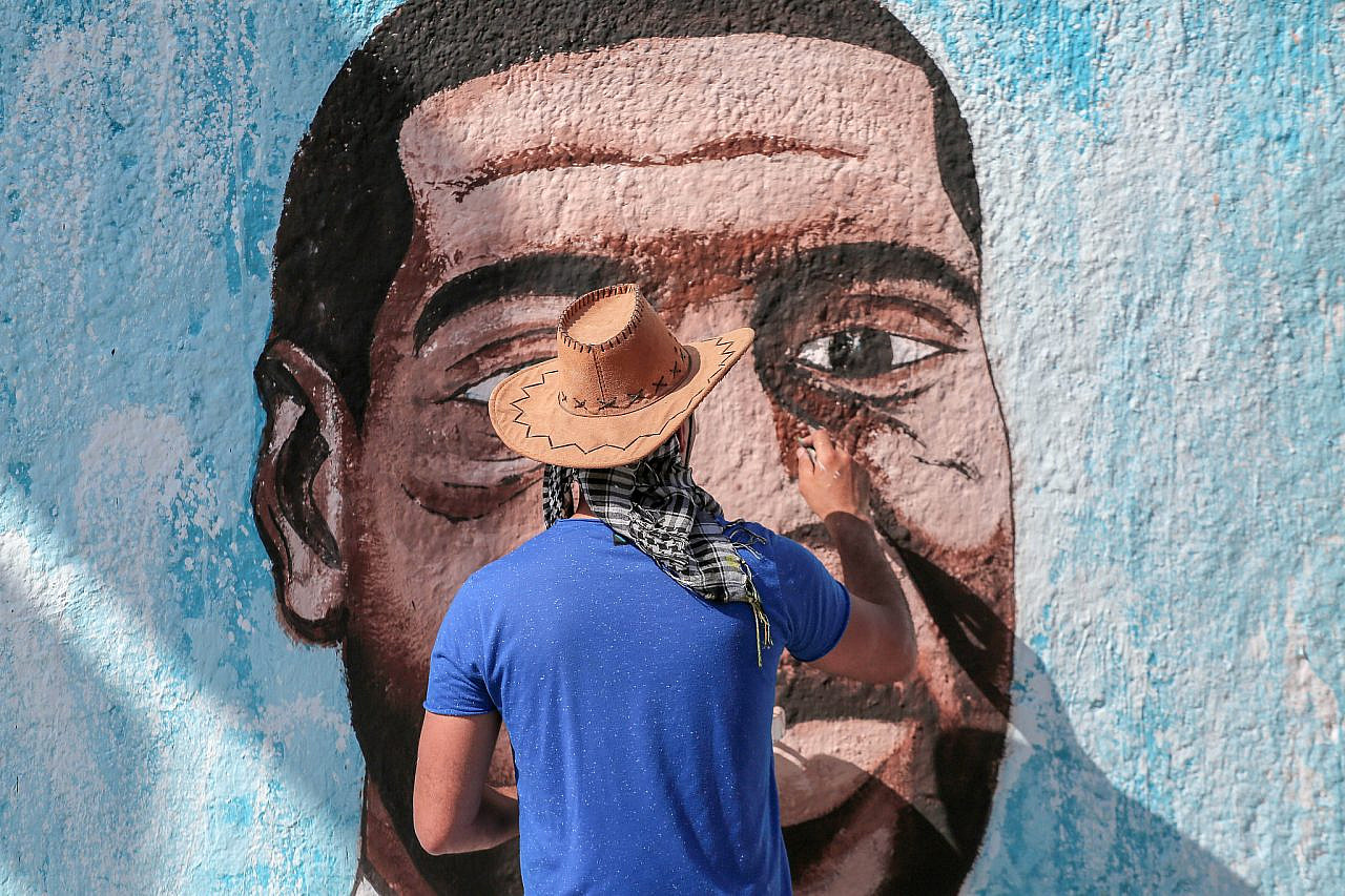A Palestinian artist paints a mural of George Floyd, an African-American man who was killed in Minneapolis, Minnesota, by police officers, Gaza City, June 16, 2020. (Mohammed Zaanoun/Activestills)