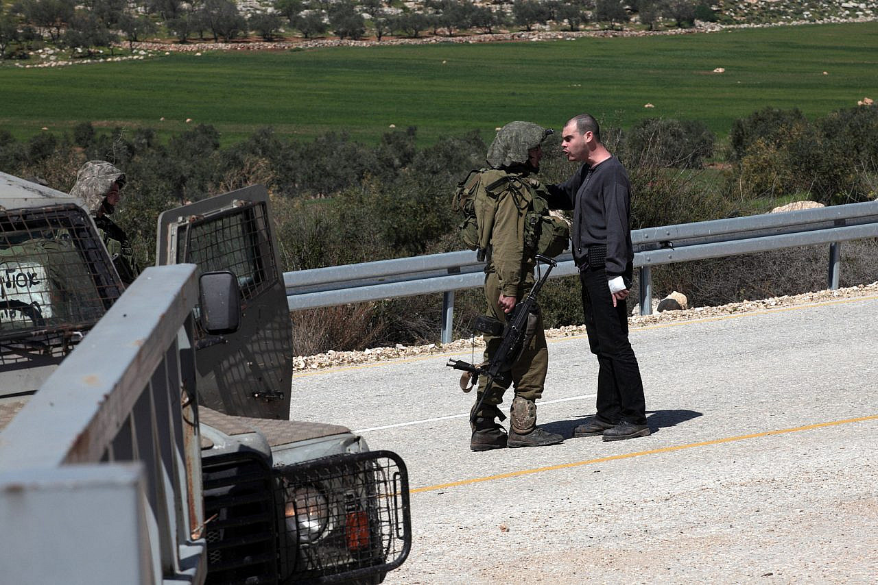 Jonathan Pollak confronts an Israeli soldier during a demonstration against the closure of the main road in the Palestinian village of Beit Dajan, near Nablus, occupied West Bank, Friday, March 9, 2012. (Anne Paq/Activestills)