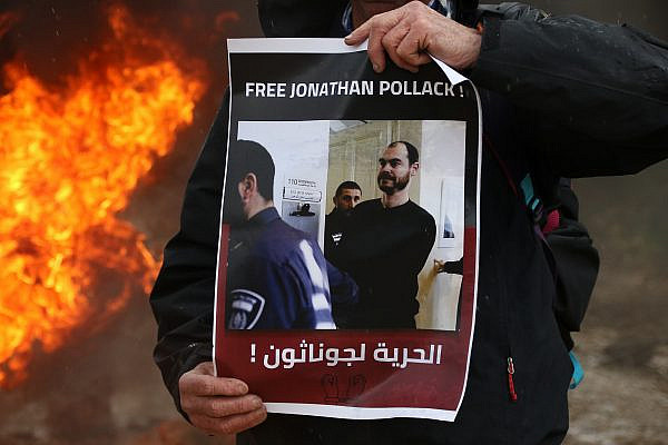 Activists hold up posters in support of Jonathan Pollak at the weekly protest in the Palestinian town of Beita, occupied West Bank, February 3, 2023. (Wahaj Banimoufleh)