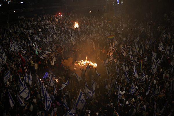 Tens of thousands of demonstrators protest on Ayalon Highway following Prime Minister Benjamin Netanyahu's dismissal of Defense Minister Yoav Gallant, March 26, 2023. (Oren Ziv)
