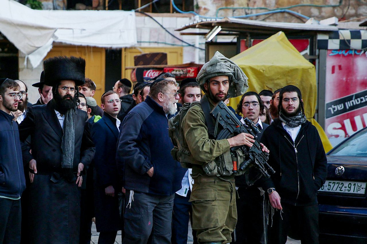 Israeli security forces guard as Jewish settlers tour the West Bank city of Hebron, January 7, 2023. (Wisam Hashlamoun/Flash90)