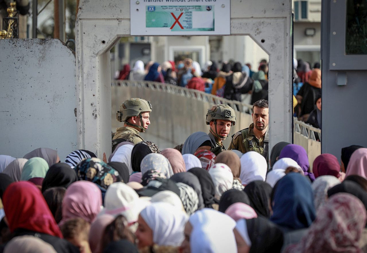 Palestinians make their way through an Israeli checkpoint to attend the first Friday prayers of Ramadan in Jerusalem's Al-Aqsa Mosque, Bethlehem, West Bank, March 24, 2023. (Wisam Hashlamoun/Flash90)