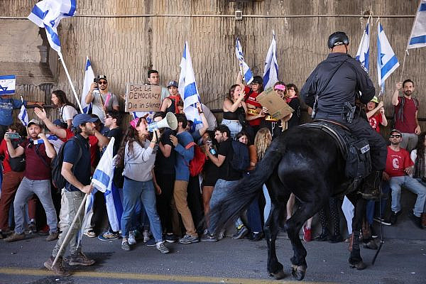Israeli protesters clash with police on horseback while blocking Ayalon Highway during an anti-government demonstration, March 16, 2023. (Oren Ziv)