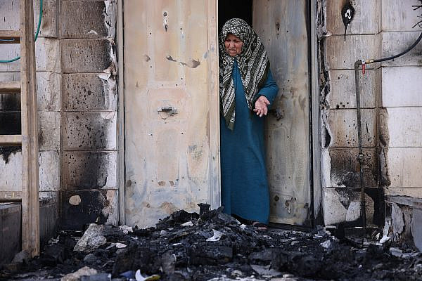 Nawal Domedi looks at the entrance to her house after it had been burned in a settler pogrom in the Palestinian town of Huwara, West Bank, February 28, 2023. (Oren Ziv)