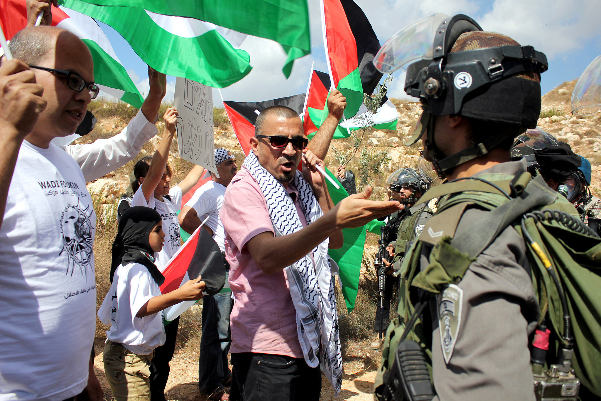 Palestinians confront Israeli soldiers during a protest against Israel's decision to confiscate 1,500 dunams of land in the village of Wadi Fukin, near Bethlehem, West Bank, September 26, 2014. (Mustafa Bader/Activestills)