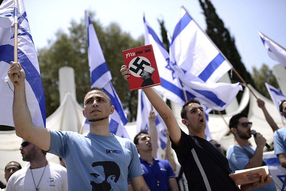 Far-right Israeli activists from the Im Tirzu movement at Tel Aviv University hold book showing Palestinian leader Amin al-Husseini with a swastika, during a protest against the annual Nakba ceremony, May 11, 2014. (Tomer Neuberg/Flash90)