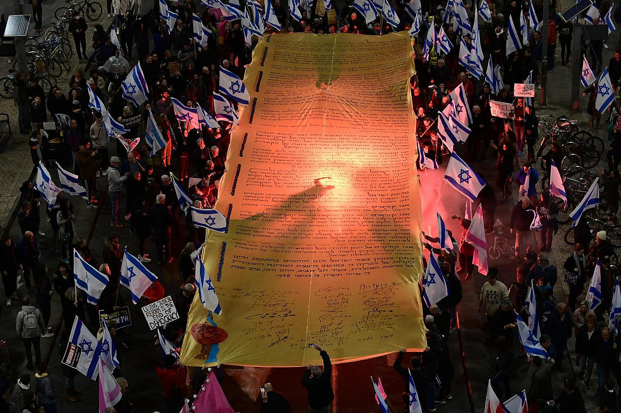 Israelis carry a giant replica of the Israeli Declaration of Independence at a protest against the current Israeli government and their planned judicial overhaul, Tel Aviv February 18, 2023. (Tomer Neuberg/FLASH90)