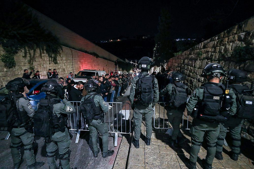 Israeli security forces stand guard while Muslim worshipers pray outside the Lion's Gate in Jerusalem's Old City, during the holy month of Ramadan, April 5, 2023. (Jamal Awad/Flash90)