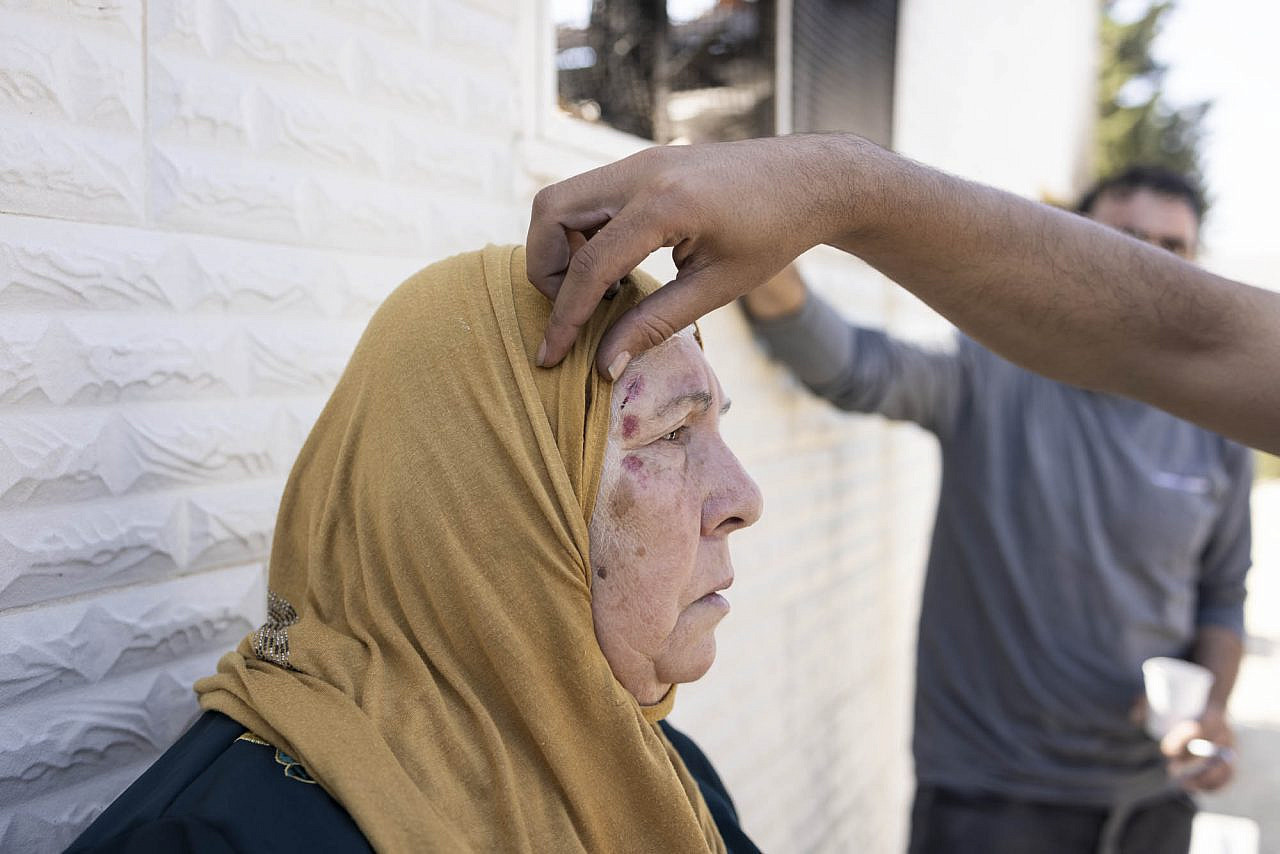 Rebiha Hijaz, 68, is treated for a head wound following a settler attack on Turmus Ayya in the occupied West Bank, June 22, 2023. (Oren Ziv)