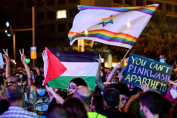 People hold a Palestinian flag during a pride event under restrictions following the spread of the coronavirus, in Tel Aviv, June 28, 2020. (Avshalom Sassoni/Flash90)