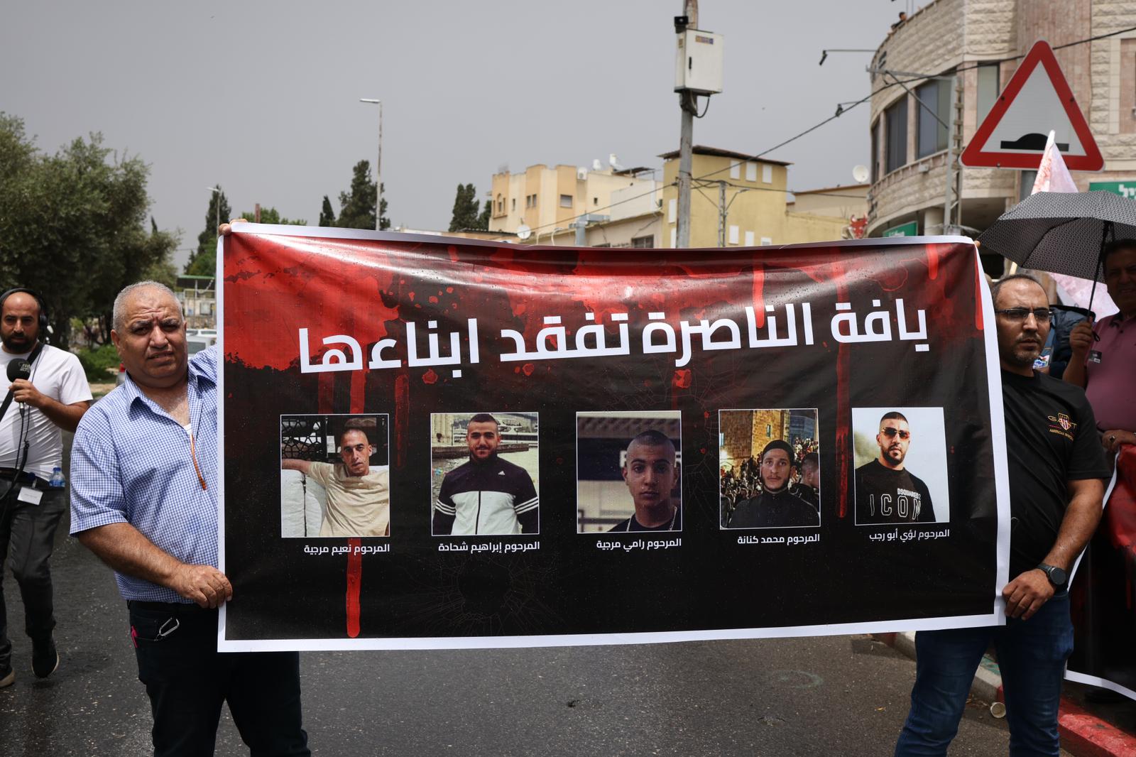 Mourners carry the images of five Palestinian citizens of Israel killed in a criminal shooting in the town of Yafa an-Nasariyye, June 9, 2023. (Oren Ziv)