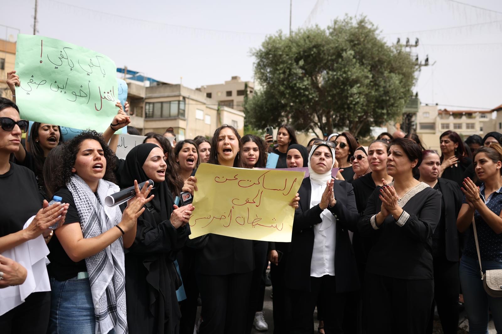 Mourners protest against violence at the funeral of 29-year-old Naeem Marjiyeh and 15-year-old Rami Marjiyeh in the the Catholic Church in the town of Yafa an-Nasariyye. The two were murdered, among three others, in a criminal shooting. June 9, 2023. (Oren Ziv)
