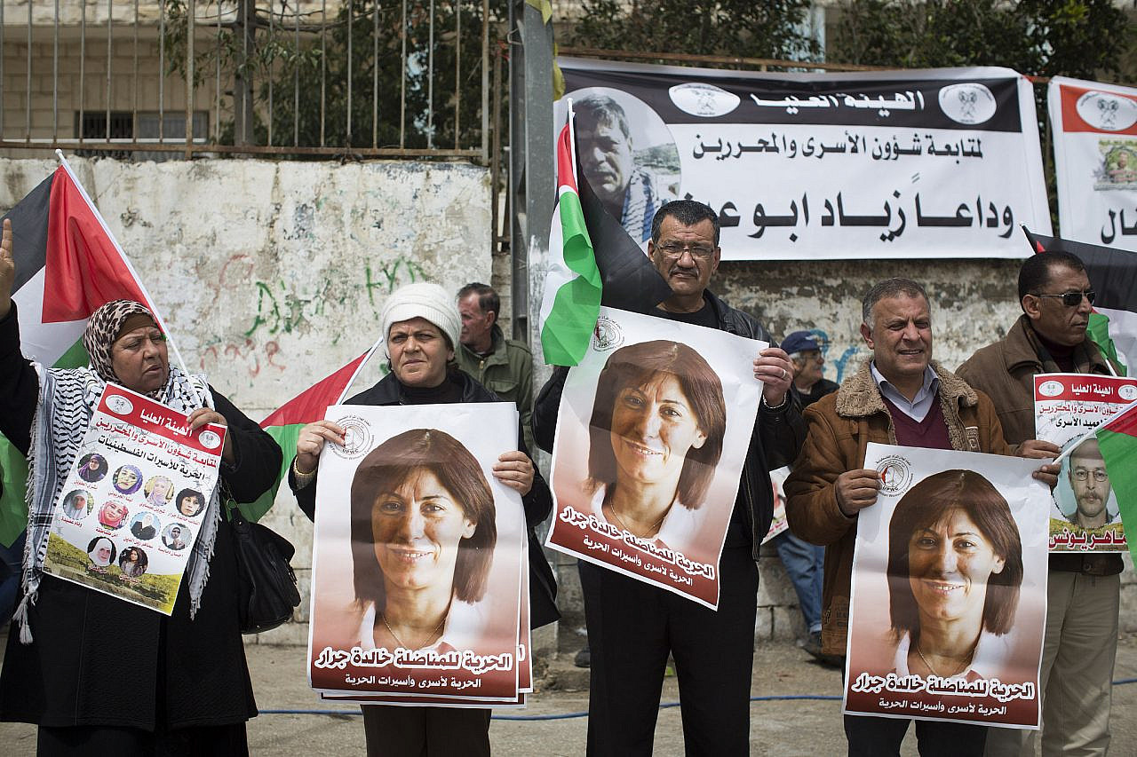 Palestinian protesters hold photos of prisoner Khalida Jarrar, a member of the PLC, during a protest marking Palestinian prisoners day, outside the Ofer military prison, occupied West Bank, April 16, 2015. (Oren Ziv/Activestills)