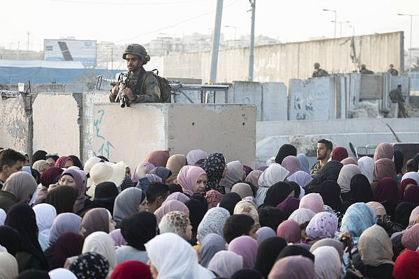 Palestinians wait to cross Qalandiya checkpoint on their way from the occupied West Bank to Al-Aqsa Mosque, Jerusalem, to take part in Friday prayers during Ramadan, April 29, 2022. (Oren Ziv)