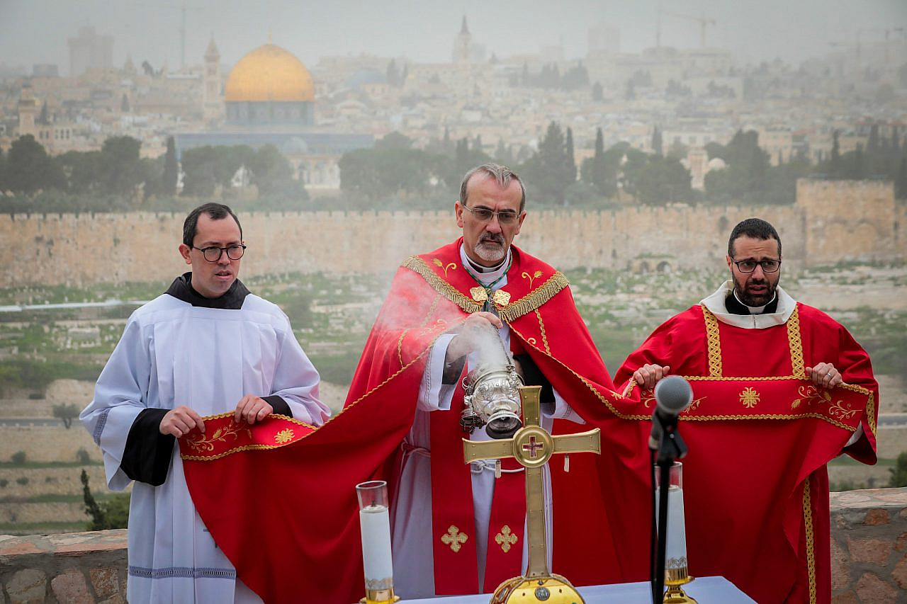 Archbishop Pierbattista Pizzaballa, Apostolic Administrator of the Latin Patriarchate of Jerusalem leads a Palm Sunday procession mass in the Mount of Olives overlooking the Old City of Jerusalem, April 5, 2020. (Yossi Zamir/Flash90)