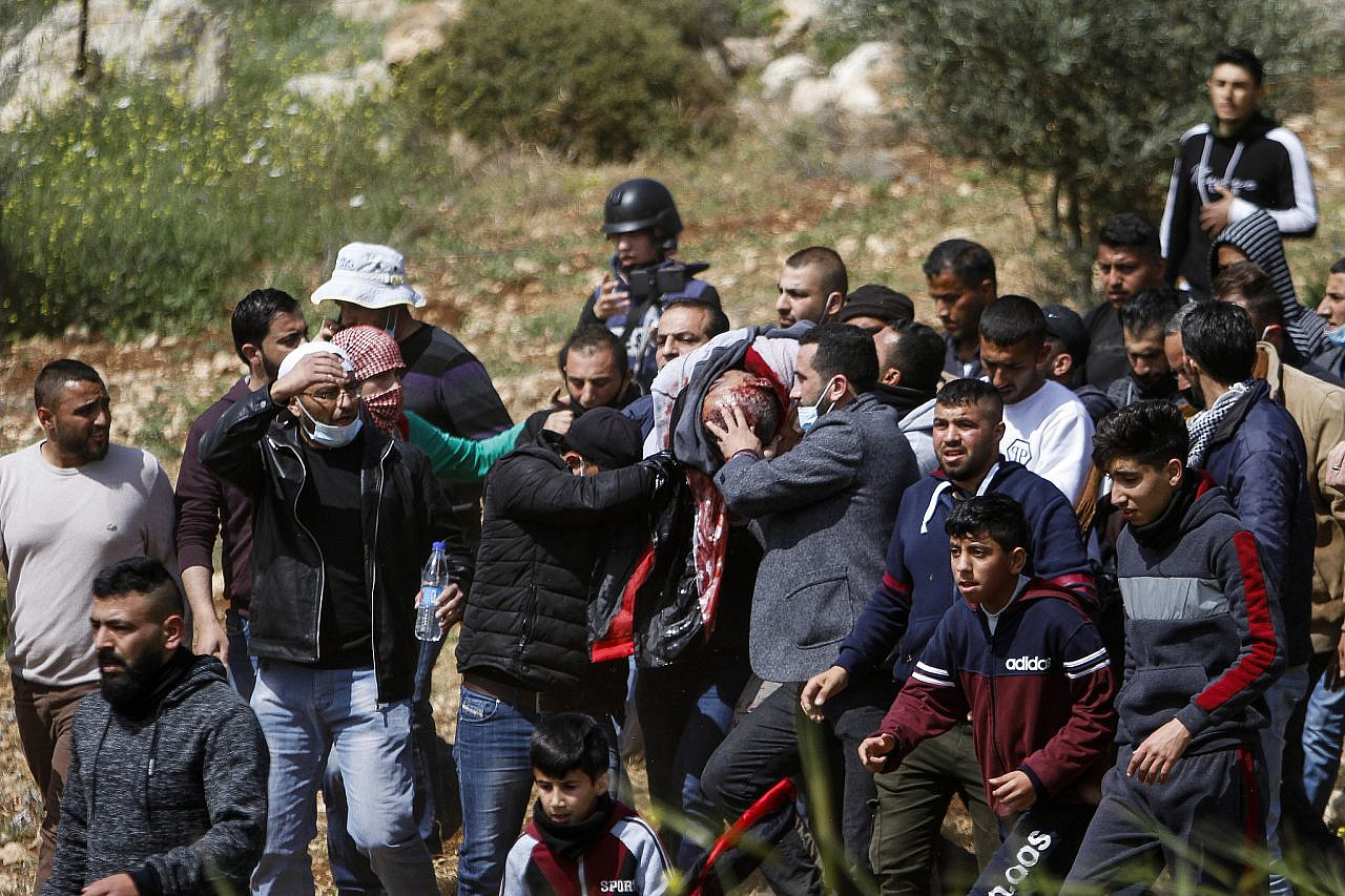 Palestinians carry fatally wounded 47-year-old Atef Hanaysha, who was shot by Israeli forces during a protest in the village of Beit Dajan, near the occupied West Bank city of Nablus, March 19, 2021. (Nasser Ishtayeh/Flash90)