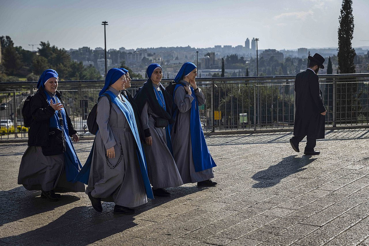Catholic nuns walked pass an ultra orthodox man as they walk outside the Old city of Jerusalem on December 01, 2022. (Olivier Fitoussi/Flash90)