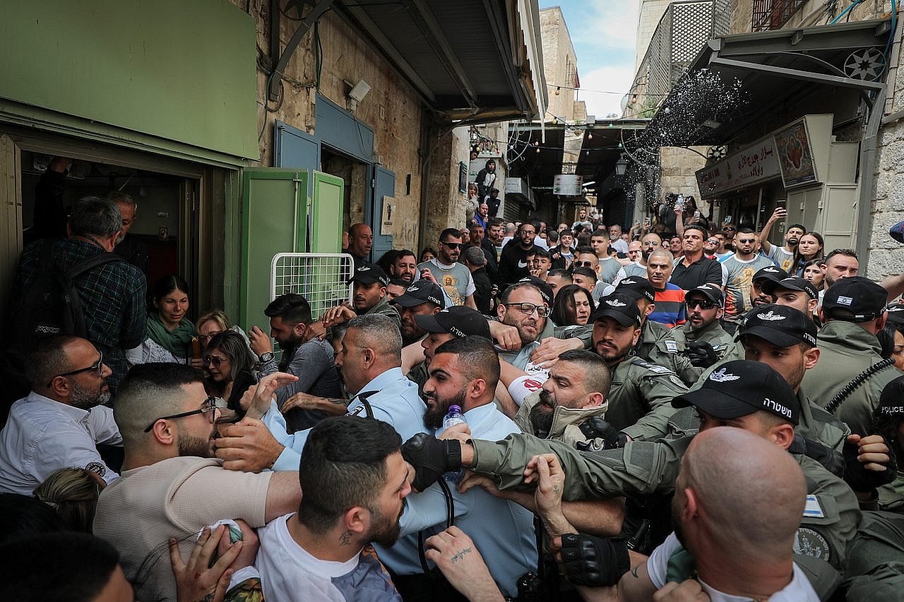 Christian worshippers scuffle with police in the tight alleyways of Jerusalem's Old City, as thousands take part in the Holy Fire ceremony at the Church of the Holy Sepulchre during Easter, April 15, 2023. (Jamal Awad/Flash90)