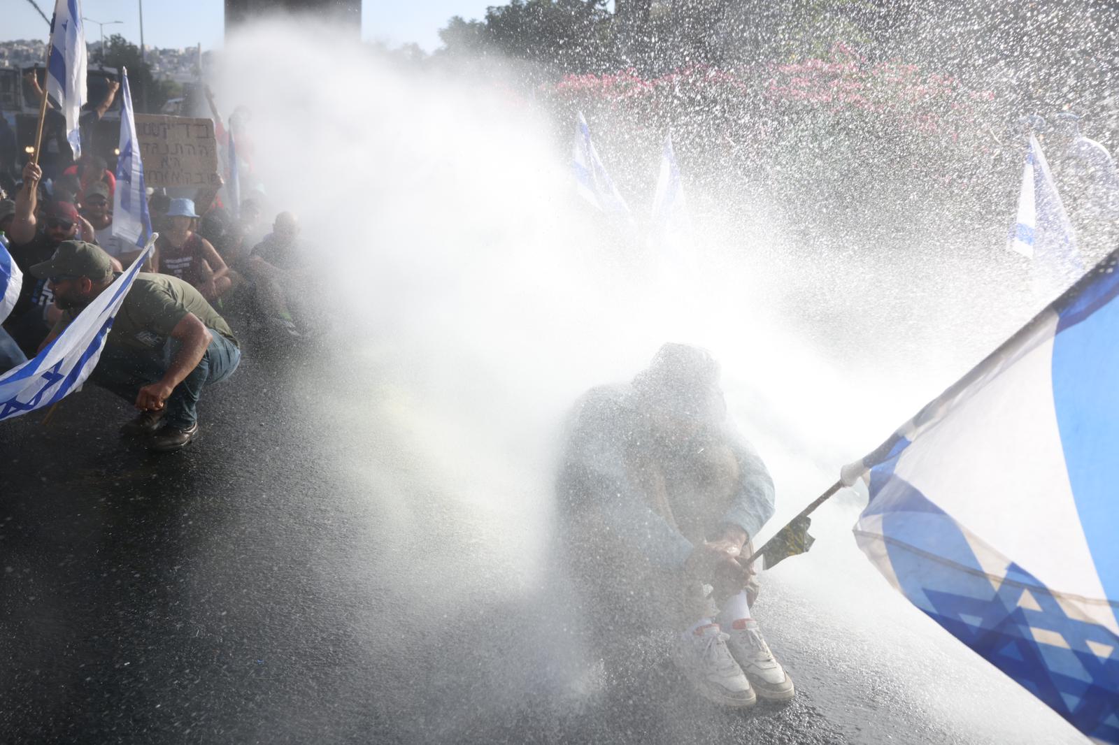 Israeli police use a water cannon against anti-government protesters outside the Knesset, Jerusalem, July 24, 2023. (Oren Ziv)