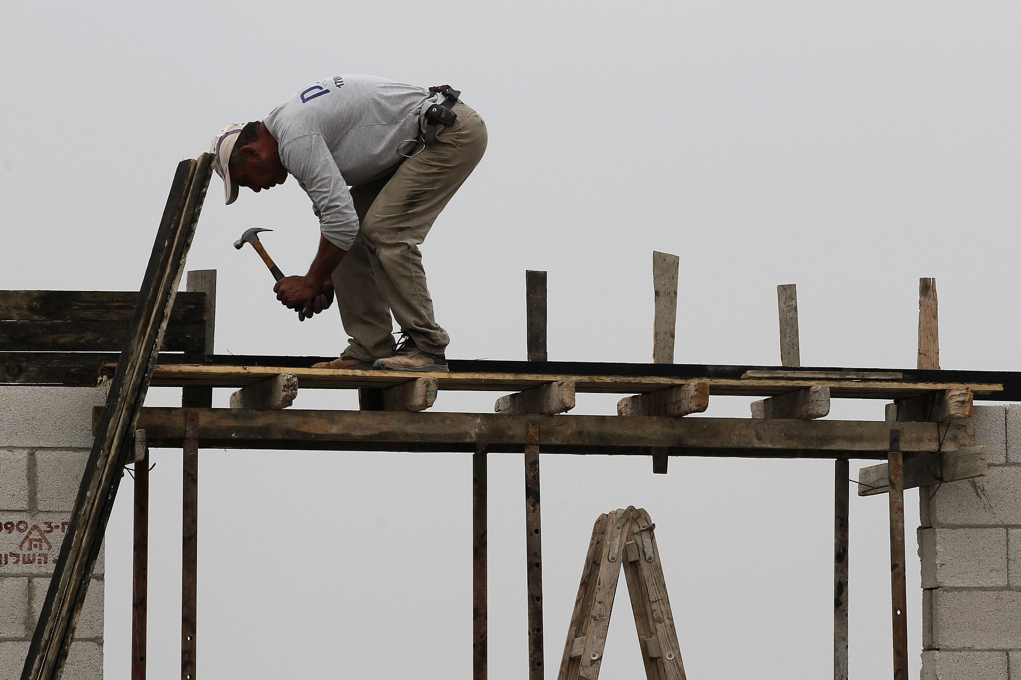 A Palestinian construction laborer works on the expansion of the Jewish settlement of Tzufim, near the West Bank town of Qalqilya, October 31, 2012. (Nati Shohat/Flash90)