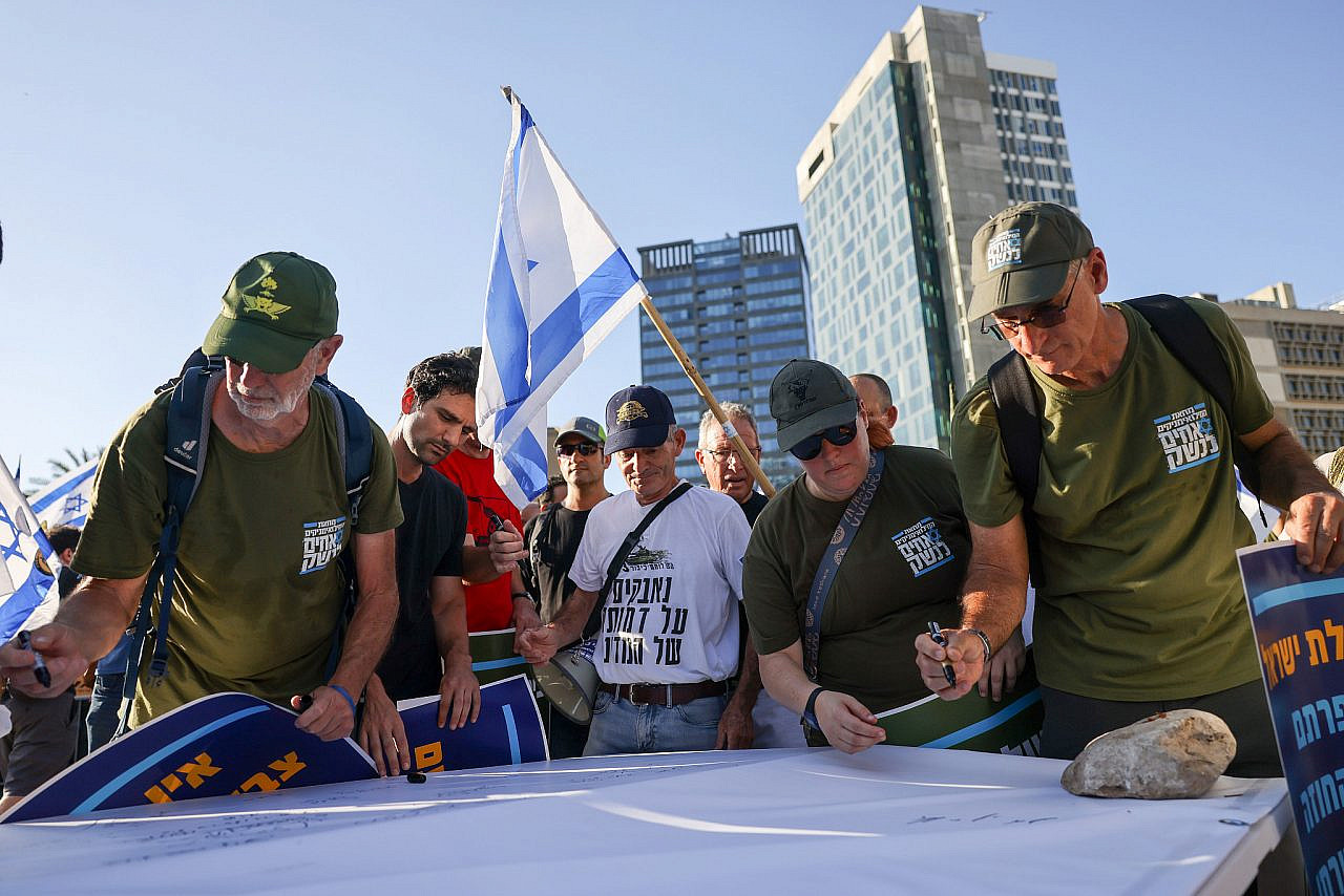 IDF reserve soldiers sign a statement saying they will not continue to do reserve military service as part of a protest against the government's planned judicial overhaul, Tel Aviv, July 19, 2023. (Chaim Goldberg/Flash90)