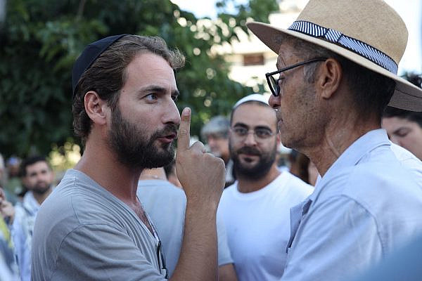 Protesters argue with worshippers affiliated with the Rosh Yehudi organization over gender-segregated prayer on Yom Kippur in Dizengoff Square, Tel Aviv, September 25, 2023. (Oren Ziv)