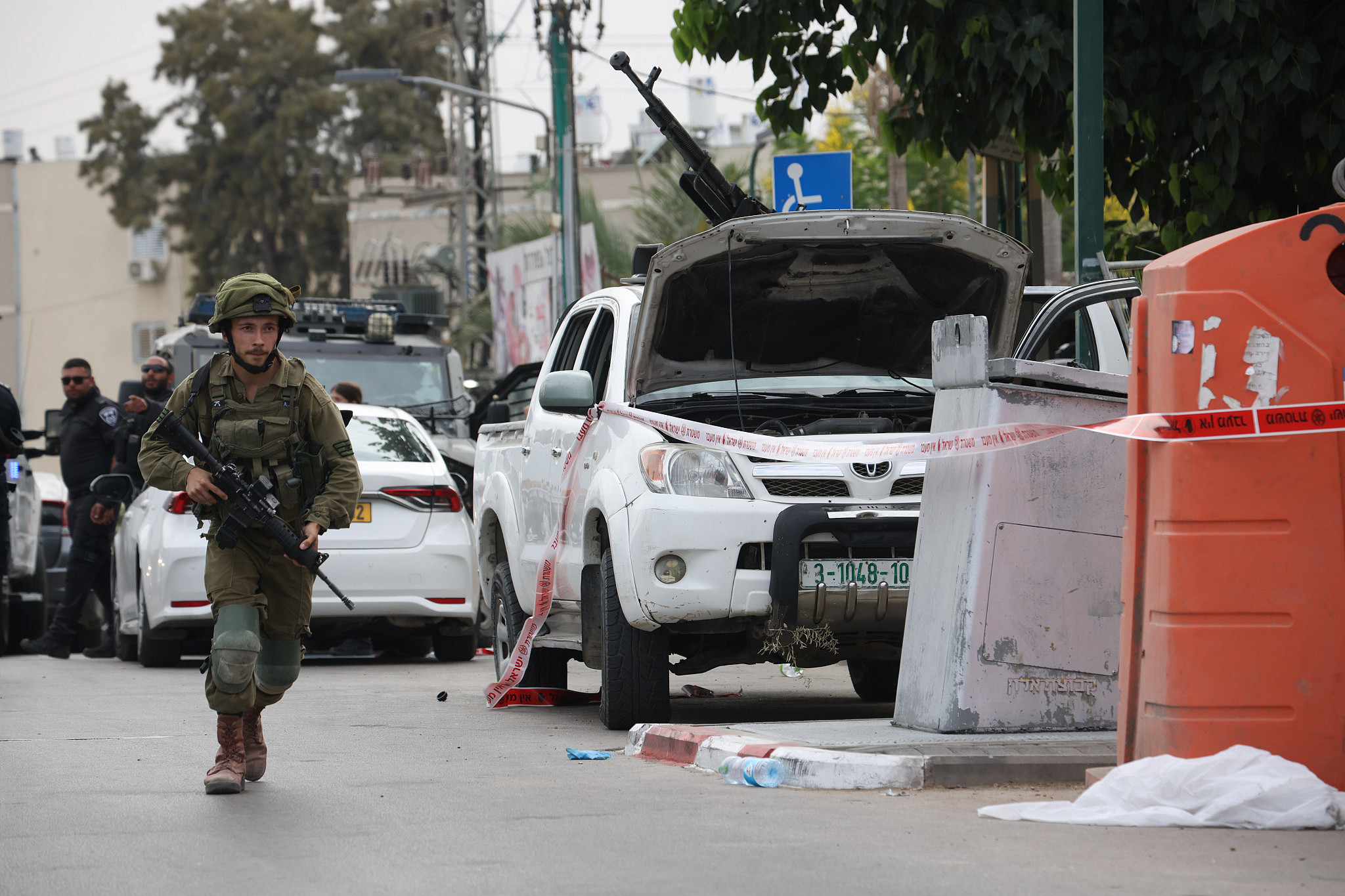 An Israeli soldier runs near Sderot police station, which Hamas militants captured, October 7, 2023. (Oren Ziv)