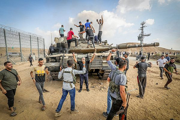 Palestinians take control of an Israeli tank after crossing the fence with Israel from Khan Yunis in the southern Gaza Strip, October 7, 2023. (Abed Rahim Khatib/Flash90)