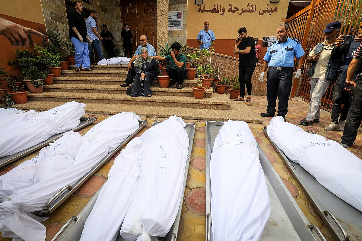 Palestinians mourn beside the bodies of people killed in Israeli airstrikes, Khan Yunis, southern Gaza Strip, October 11 2023. (Abed Rahim Khatib/Flash90)