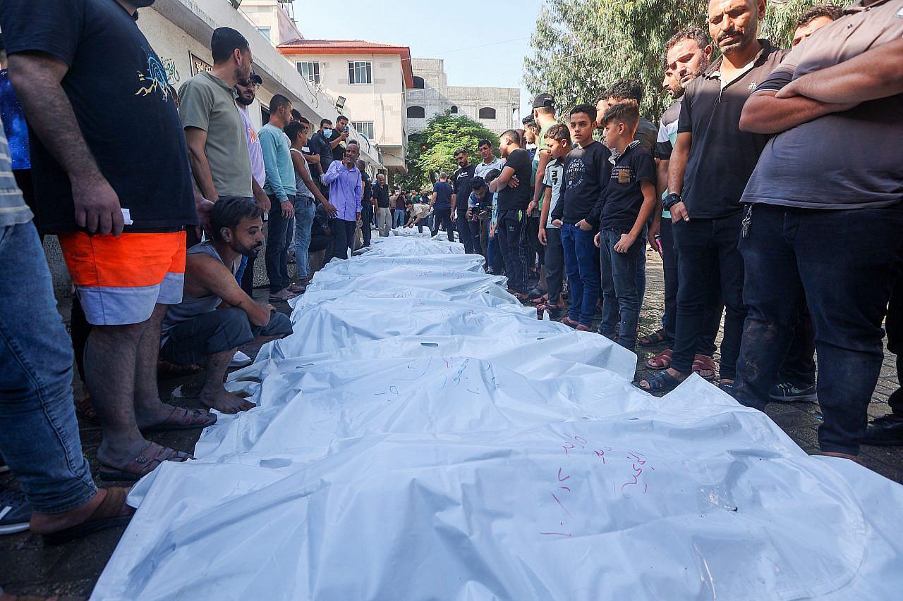 Palestinians mourn near bodies of those killed in Israeli air strikes, outside Al-Shifa Hospital in Gaza City, October 12, 2023. (Atia Mohammed/Flash90)