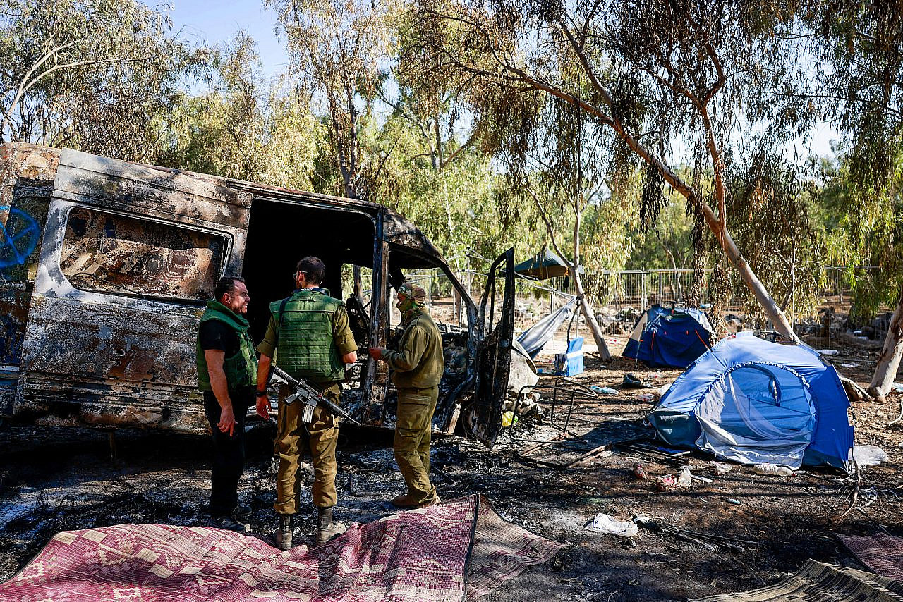 Israeli forces inspect the site of a musical festival in Re'im where hundreds of Israelis were killed and kidnapped by Hamas militants, southern Israel, October 12, 2023. (Chaim Goldberg/Flash90)