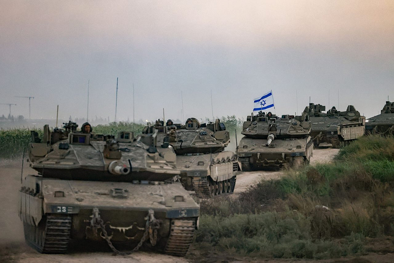 A convoy of Israeli tanks at sunset seen near on the Israeli side of the Gaza fence, October 12, 2023. (Chaim Goldberg/Flash90)