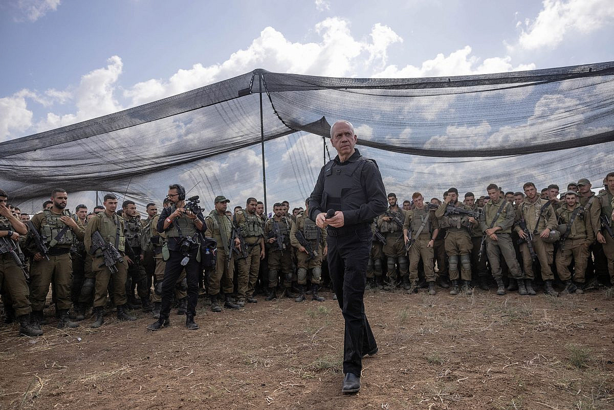 Defense Minister Yoav Gallant speaks with Israeli soldiers at a staging area not far from the Israeli-Gaza border, October 19, 2023. (Chaim Goldberg/Flash90)