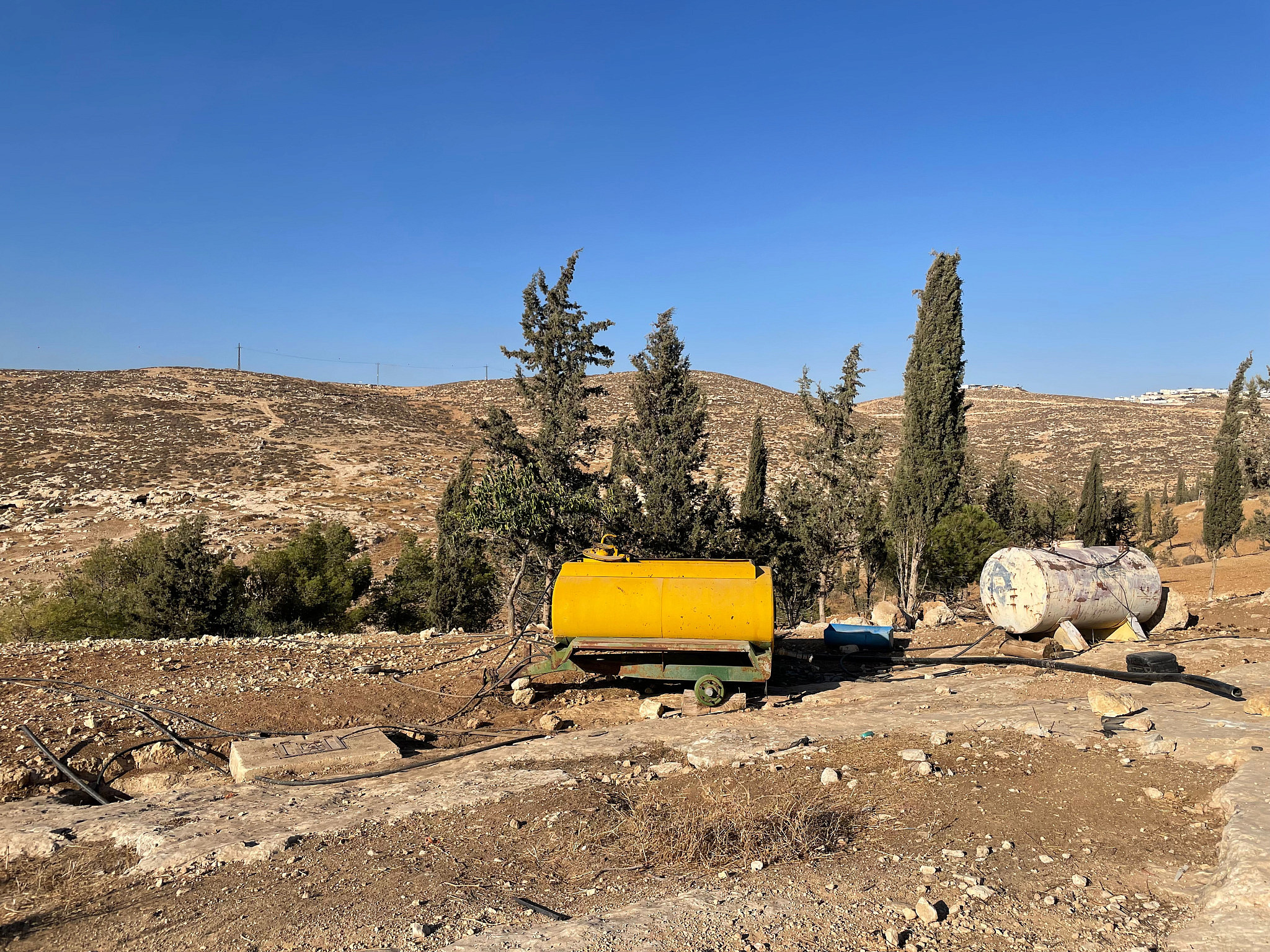 Supplementary water tanks in Ar-Ratheem with the Israeli settler outpost of Asa'el in the backdrop. (Natasha Westheimer)