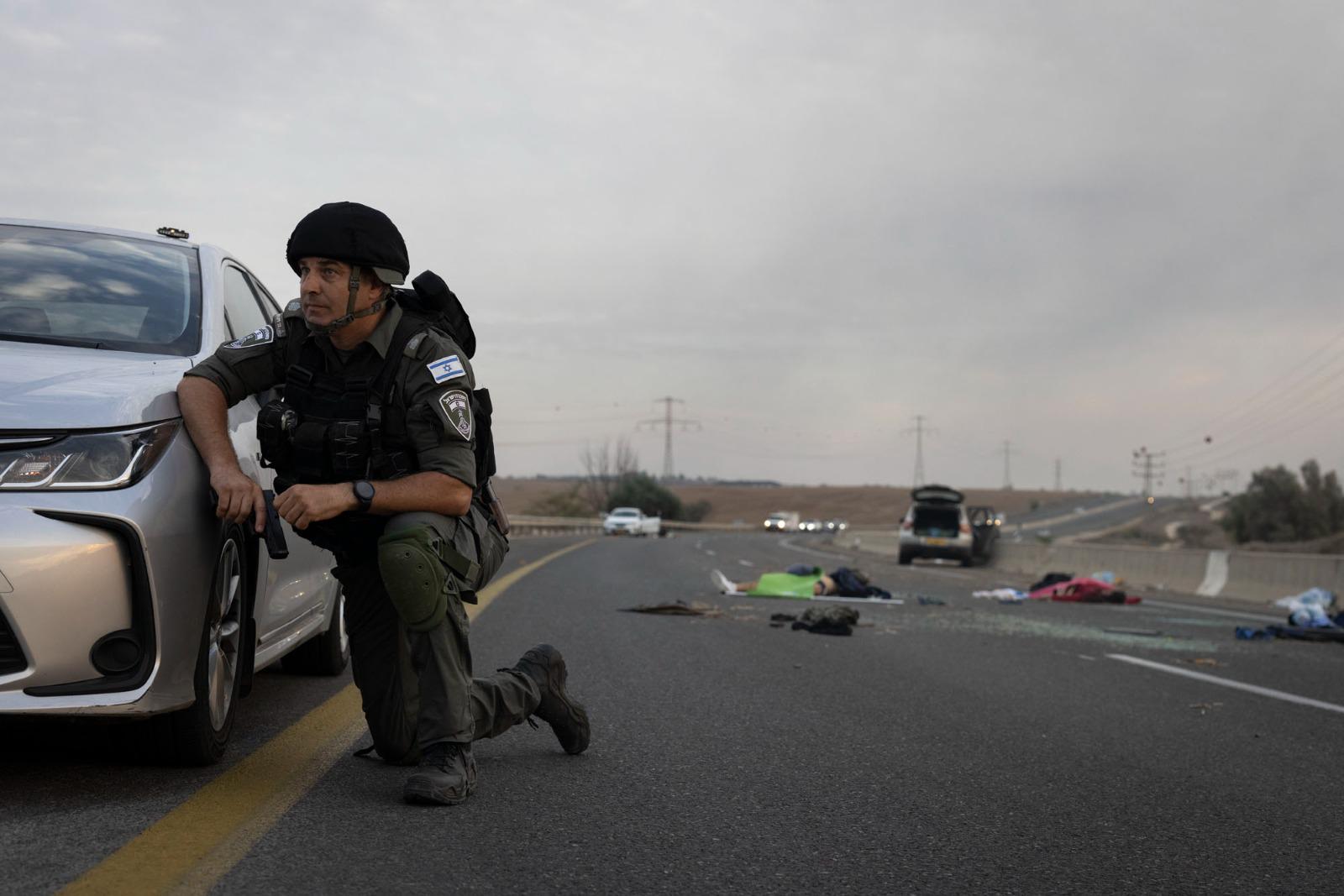 An Israeli Border Police officer on a highway between Netivot and Sderot, where Israelis were killed by Hamas militants, October 7, 2023. (Oren Ziv)