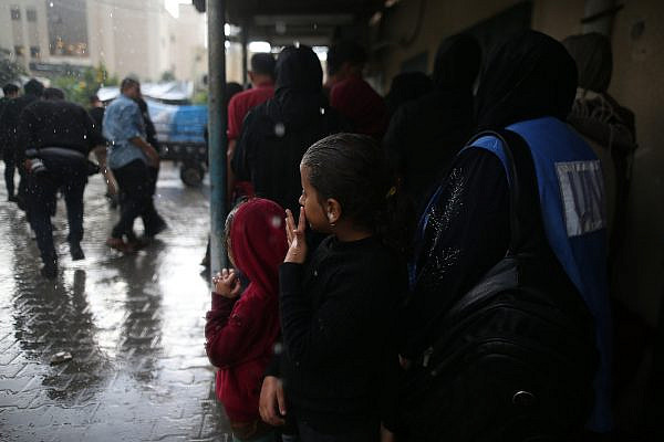 Palestinian families shelter from the rain at Nasser Hospital in Khan Younis, southern Gaza Strip, November 14, 2023. (Mohammed Zaanoun)