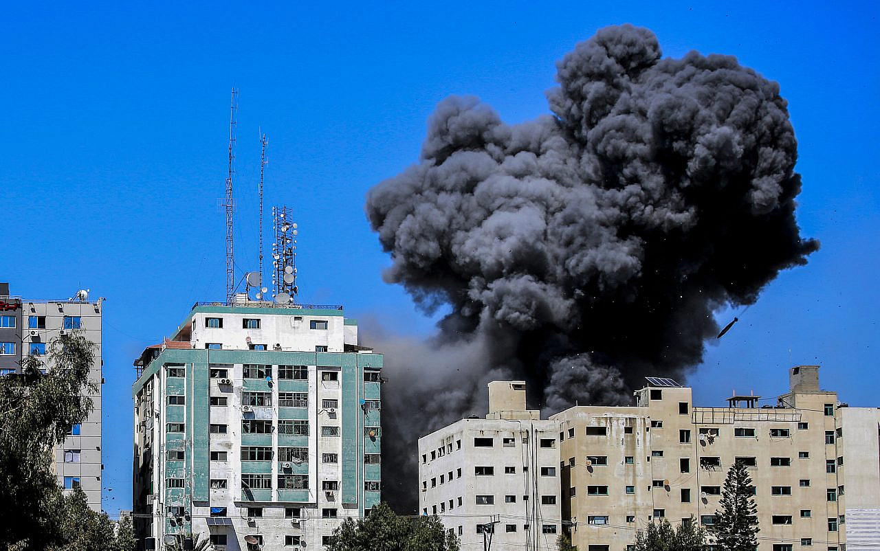 Smoke rises after an Israeli airstrike hits Al-Jalaa tower, which houses apartments and several media outlets including the Associated Press and Al Jazeera, Gaza City, May 15, 2021. (Atia Mohammed/Flash90)