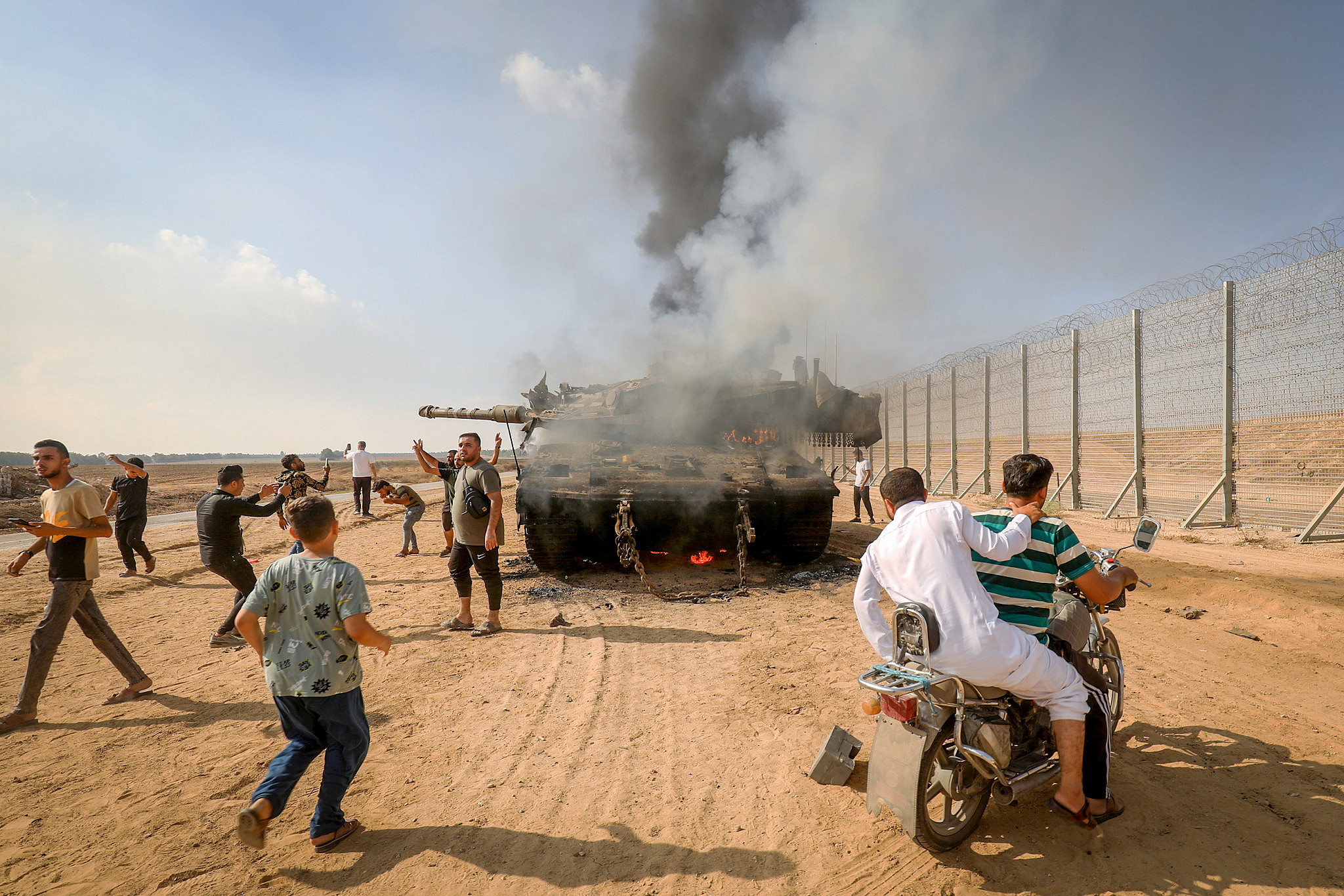 Palestinians take control of an Israeli tank after crossing the Gaza fence into Israel from Khan Younis, southern Gaza Strip, October 7, 2023. (Abed Rahim Khatib/Flash90)
